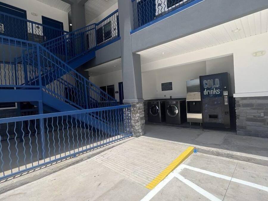 A multi-level indoor area with blue railings, a vending machine labeled "COLD drinks," and a visible exit sign.