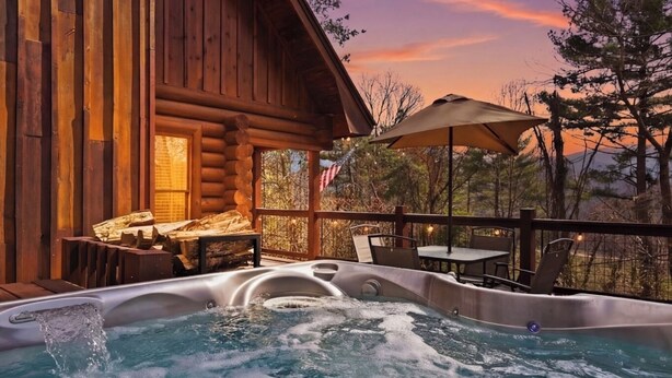 A wooden cabin with a hot tub and outdoor seating.