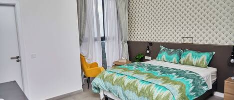Een slaapkamer met een bed, een stoel, een nachtkastje en een luchtverfrisser aan de muur.