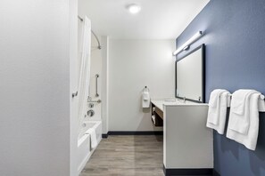 Une salle de bain moderne avec une baignoire, un lavabo et un miroir.