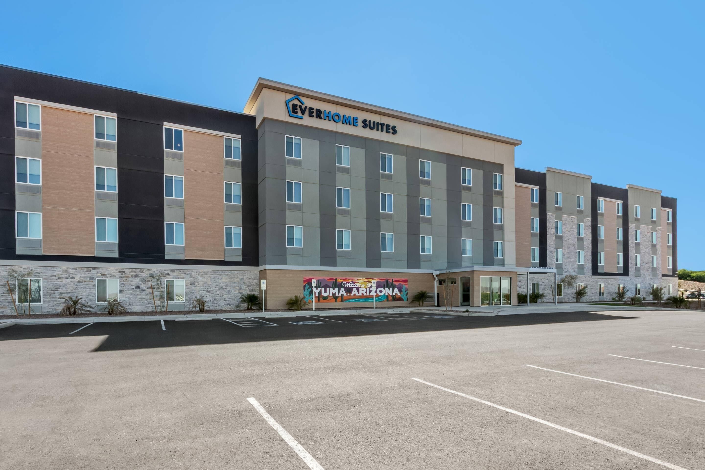 Un hôtel à plusieurs étages, sur lequel on peut lire l’inscription « Everhome Suites ».