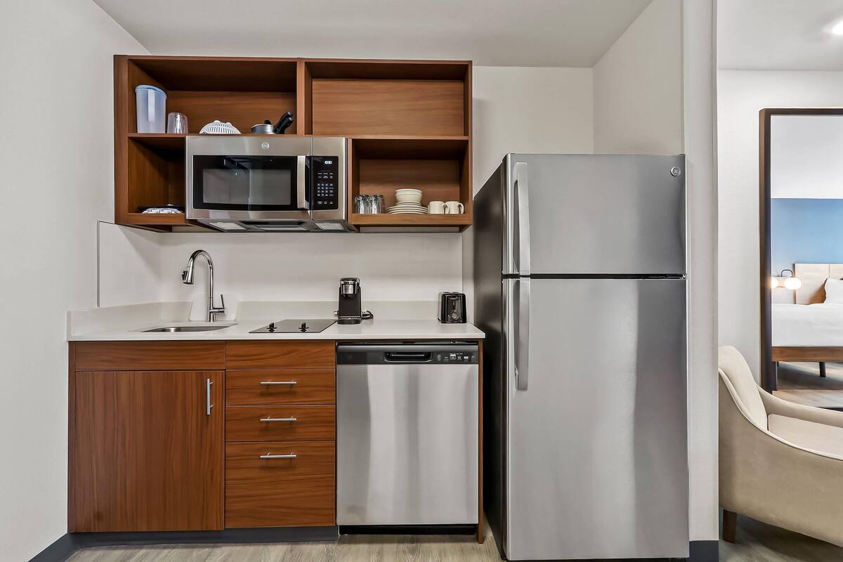 A modern kitchen with a stainless steel refrigerator, microwave, and dishwasher.