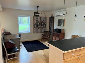 Relax in this inviting space with a large window, comfortable seating, and a unique shelving unit.