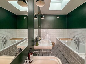 Un baño con dos lavabos, un espejo y una ducha.