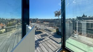 A rooftop terrace with wooden flooring, metal chairs, and potted plants. - Heart of the city Penthouse with rooftop terrace (København)