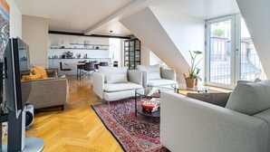 A modern apartment with a loft-style living area, a kitchen, and a dining space. - Heart of the city Penthouse with rooftop terrace (København)