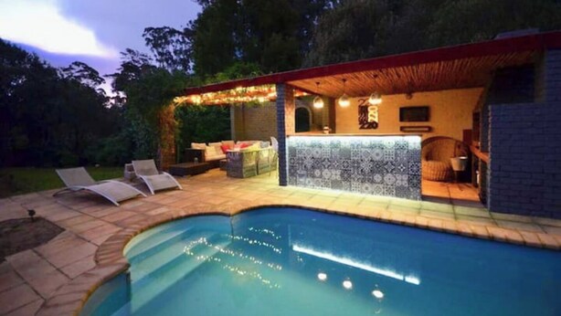 A poolside area with a bar, lounge chairs, and a covered seating area.