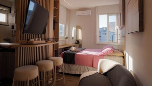 A modern bedroom with a bed, a desk, a TV, and a window. - 360 Botafogo Belair By SUHCasa (Rio de Janeiro)