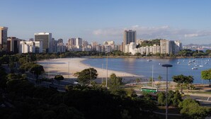 A coastal cityscape with a beach, boats, and high-rise buildings. - 360 Botafogo Belair By SUHCasa (Rio de Janeiro)