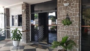 A hotel entrance with stone walls, a checkered floor, and potted plants. - 360 Botafogo Belair By SUHCasa (Rio de Janeiro)