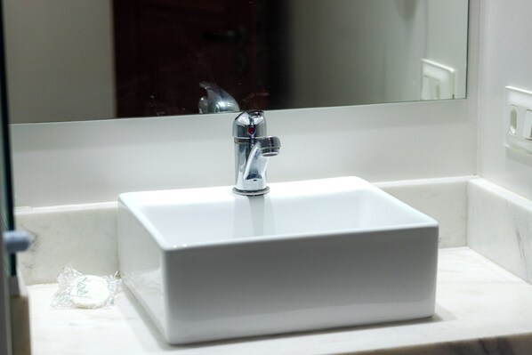 A bathroom with a white sink, a chrome faucet, and a mirror above it. - Ladeira dos Tabajaras 140 (Rio de Janeiro)