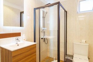 A modern bathroom with a glass-enclosed shower, a wooden vanity, and a toilet with a lid. - GuestReady - Perfect to relax in Funchal (Funchal)