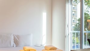 Habitación de hotel con cama, almohadas y toallas dobladas.