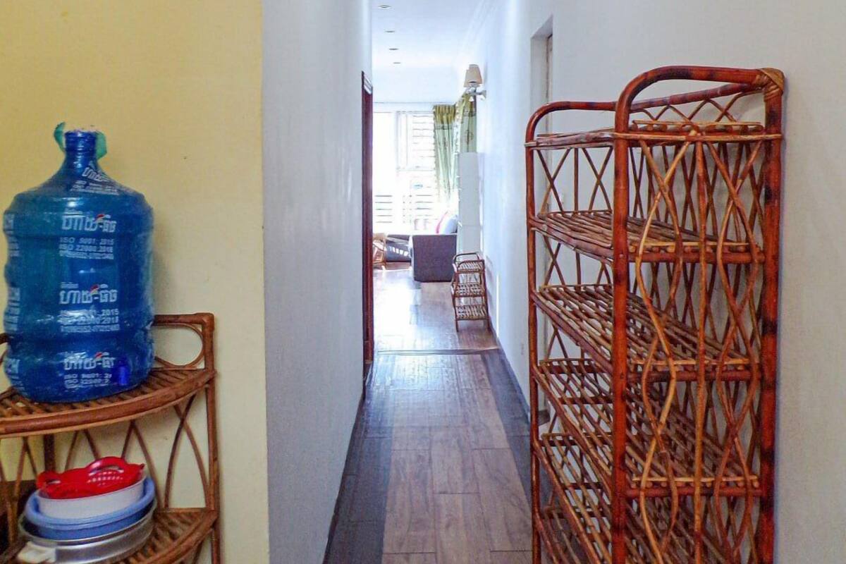 A narrow hallway with a water dispenser and stacked dishes on shelves.