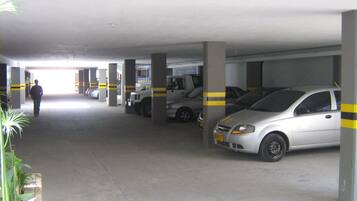 A multi-level parking garage with concrete pillars and yellow stripes.