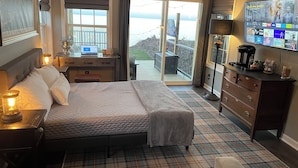 A bedroom with a bed, bedside table, lamp, dresser, and a TV displaying a show.