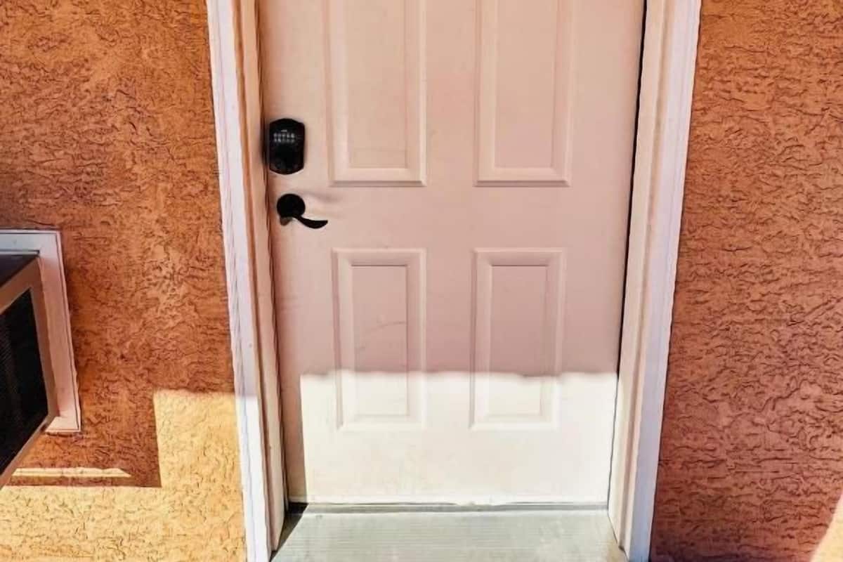 Una puerta blanca con un ventanuco y un timbre.