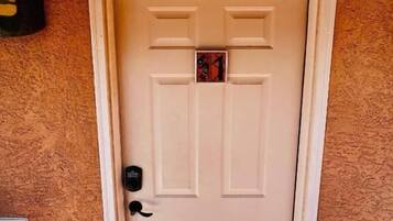 A white door with a small window and a doorbell.