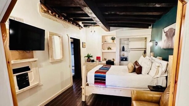 Une chambre confortable avec un lit, une télévision et une petite kitchenette.