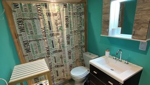 A bathroom with a toilet, sink, and a shower curtain with motivational words.