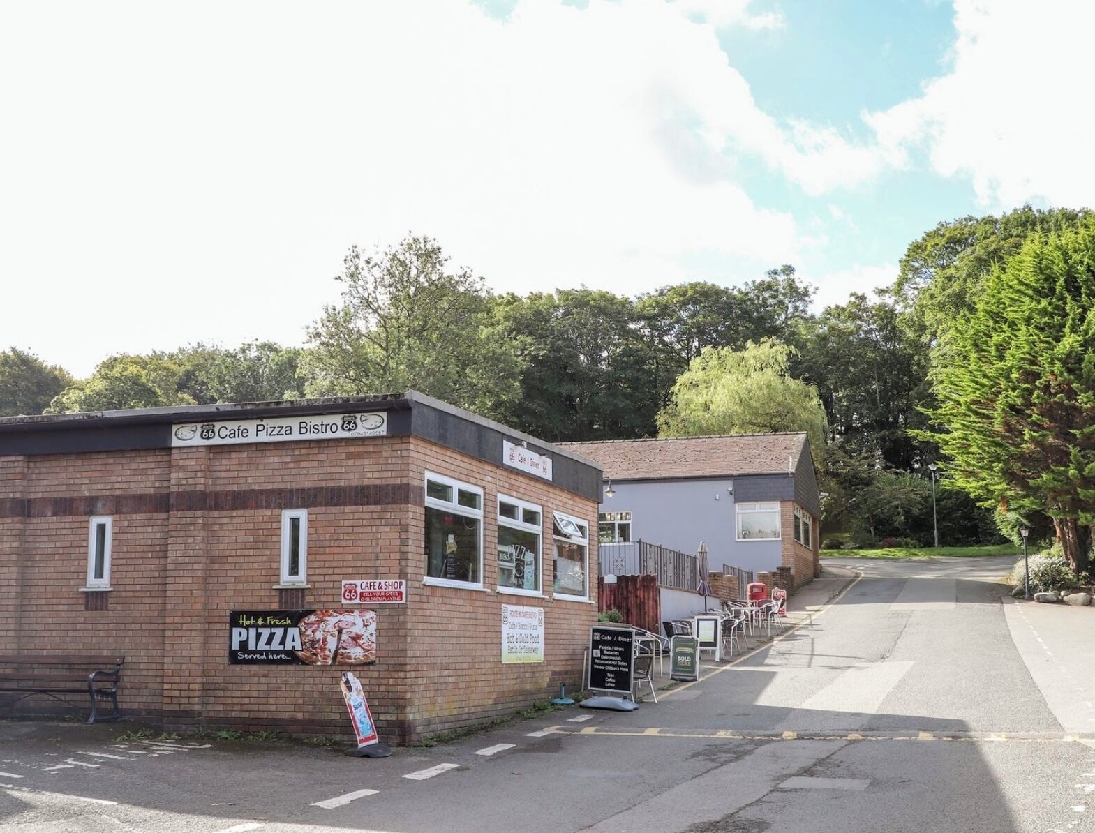 A small brick building with a sign for Cafe Pizza Bistro.