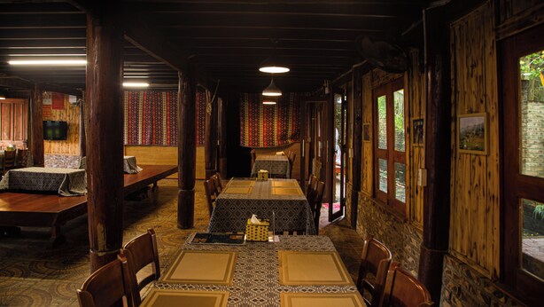 A restaurant with wooden walls and tables set for dining. - Green Sapa Homestay (Sa Pa)