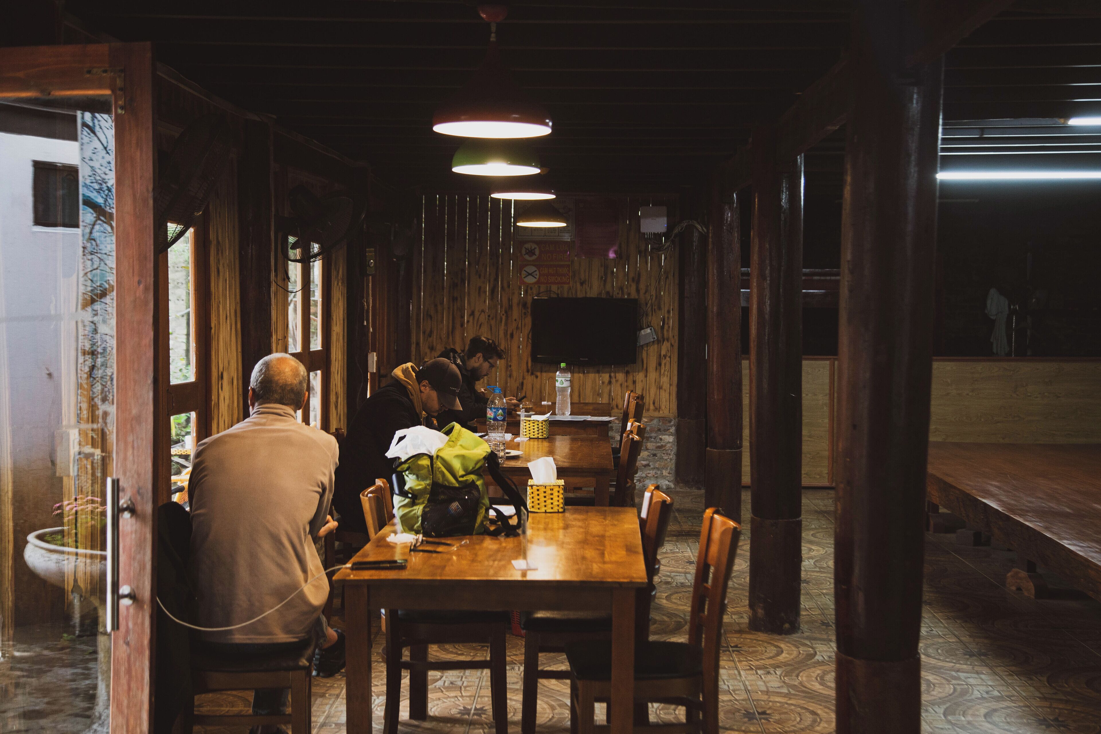 Ein Holzinterieur mit Esstisch, Stühlen und Hängeleuchten.