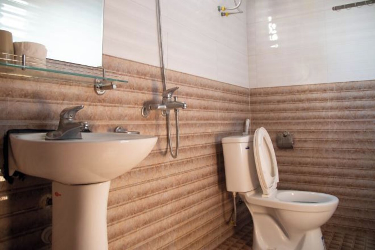 Un baño con lavamanos, inodoro y ducha.