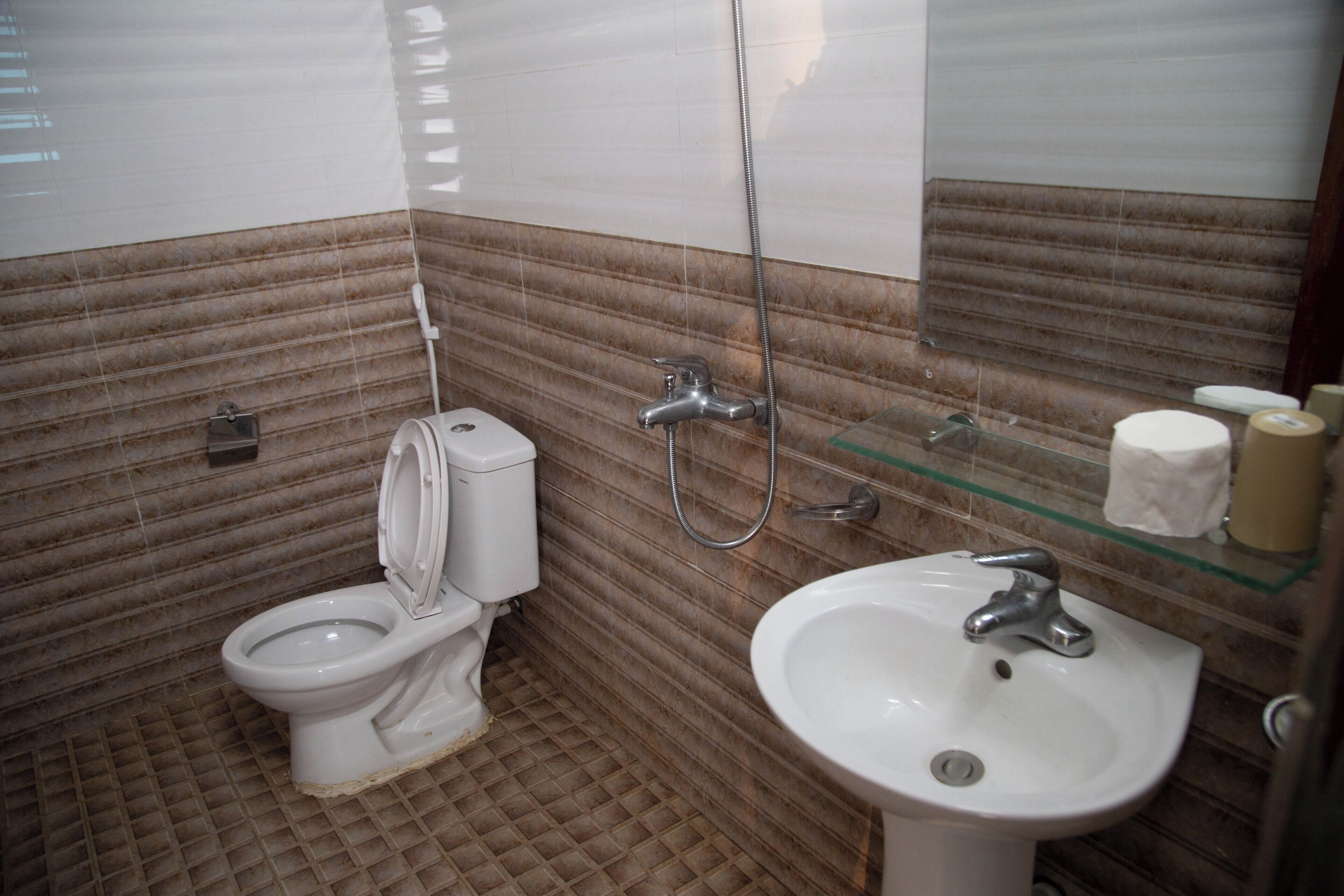 A bathroom with a toilet, a sink, and a shower.