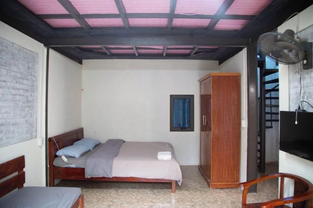 Une chambre à coucher avec un lit, une armoire, un bureau et un téléviseur.