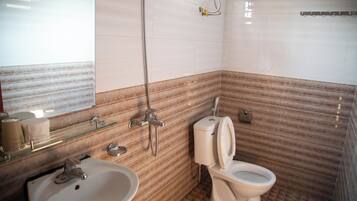 A bathroom with a sink, toilet, and shower.