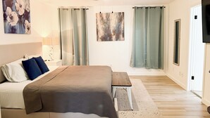 A bedroom with a bed, a ceiling fan, a painting, and a window with curtains. - Pool House near Downtown Round Rock (Round Rock)
