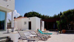 A pool area with lounge chairs, a pergola, and a small building with a door and windows. - Spacious & Private 6 bed villa close to Peyia - 5bed villa + 1bed granny annex (Peyia)