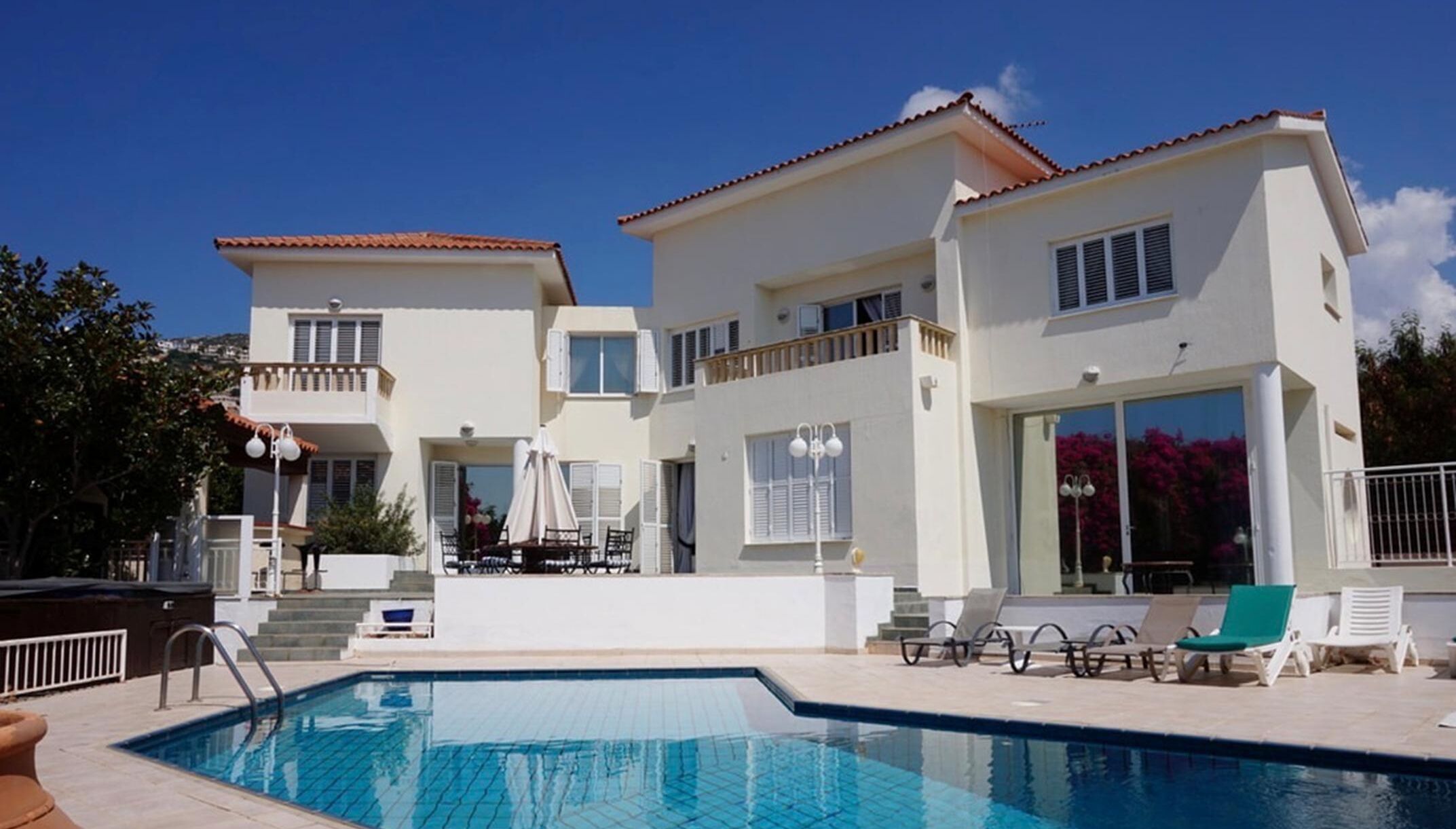 A two-story building with a swimming pool and outdoor seating.