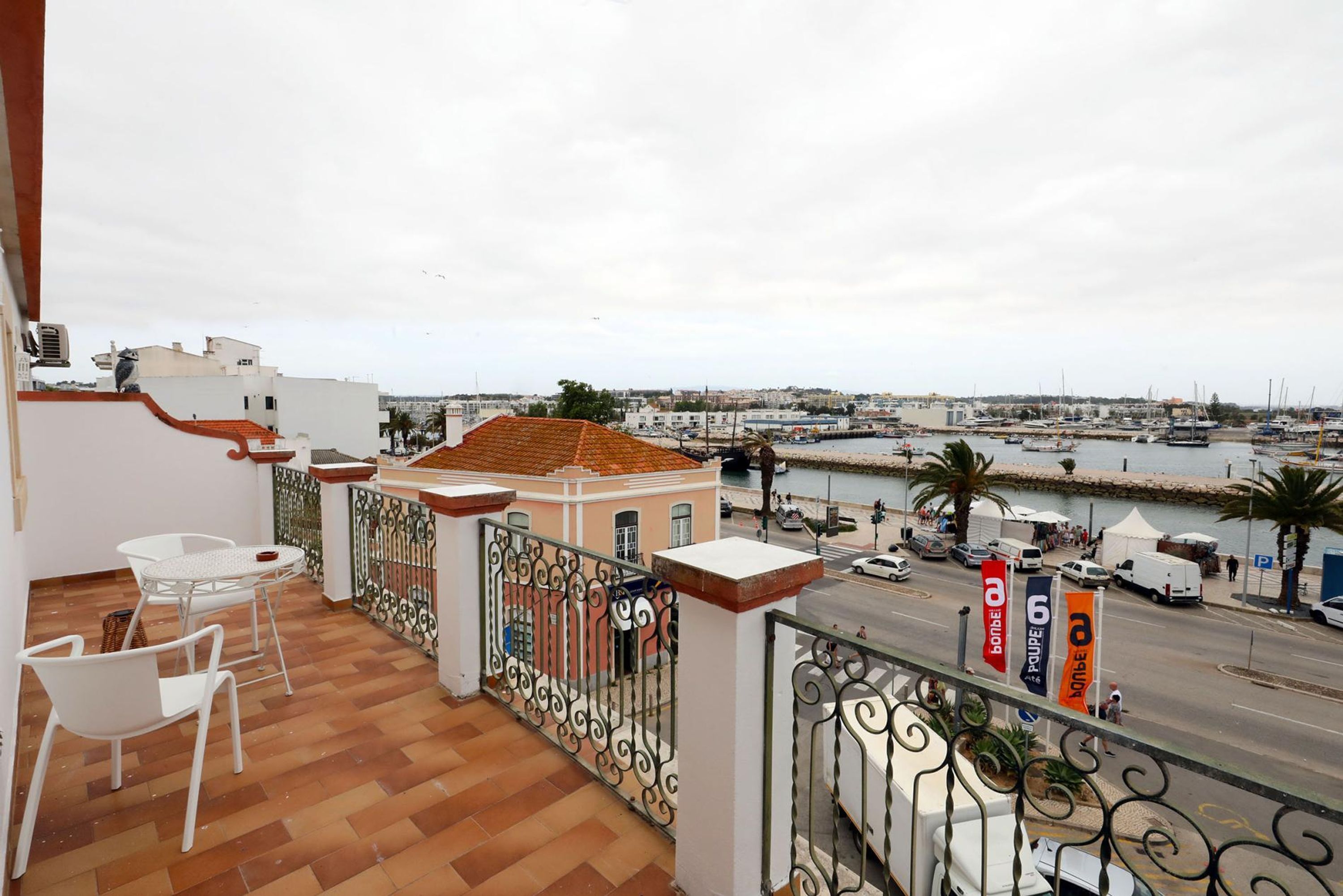 Un balcón con vista a un puerto deportivo y edificios.
