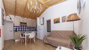 Un espace de vie compact comprenant une cuisine, un coin repas et un canapé.