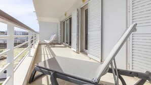 A balcony with a chair, a table, and a railing. - A69 - Felicidade Marina Apartment (Lagos)