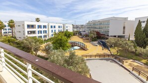 A view of a modern building complex with multiple white structures, a central courtyard with a pool, and surrounding greenery. - A69 - Felicidade Marina Apartment (Lagos)