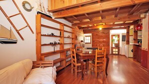 Un intérieur en bois comprenant une table à manger, des chaises, un canapé et des étagères remplies de divers objets.
