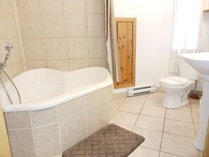 Ein Badezimmer mit Badewanne, Toilette und Waschbecken.