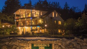 Un edificio de varios pisos con un letrero que dice 'Higgin's Inn 10150 Douglas Bay Road'.