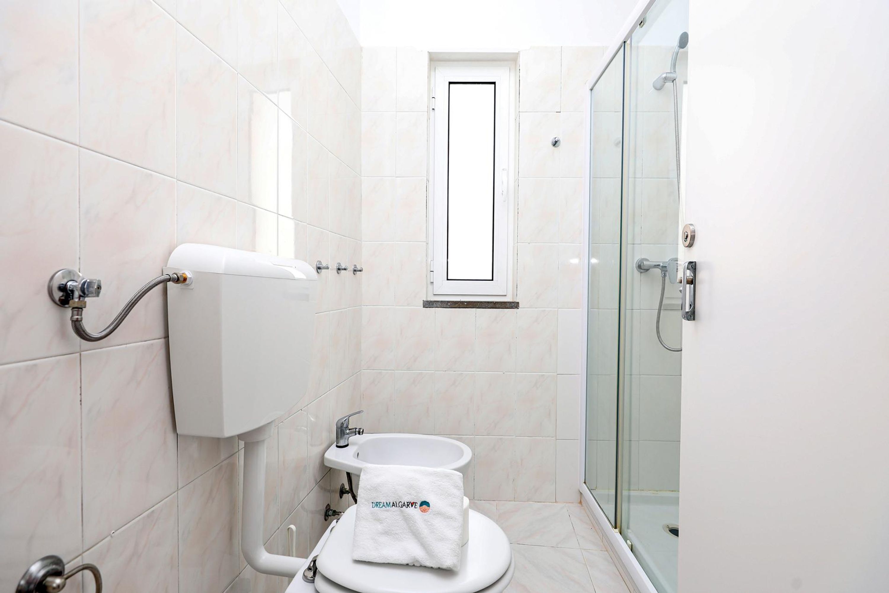 Ein modernes Badezimmer mit Toilette, Bidet und einer Duschkabine aus Glas.