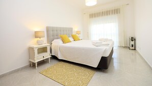 A bedroom with a bed, bedside lamps, a nightstand, a patterned rug, and a ceiling light. - C23 - Parkway Entrance Apartment in Lagos (Lagos)