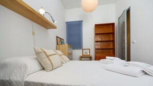 A bedroom with a bed, a nightstand, a wooden wardrobe, and a hanging light fixture. - B94 - Casa dos Peixeiros in Lagos (Lagos)