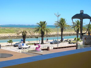 A coastal promenade with a parking area, a pedestrian walkway, and a view of the sea. - C25 - Town Center Apartment in Lagos (Lagos)