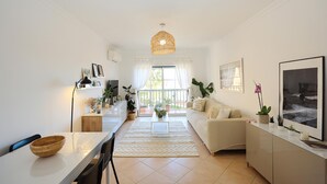 A modern living room with a sofa, a dining table, and a kitchen area. - B95 - Casa Melo Apartment in Praia da Luz (Lagos)