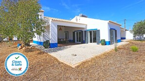 Un edificio blanco con detalles azules y un patio con baldosas.
