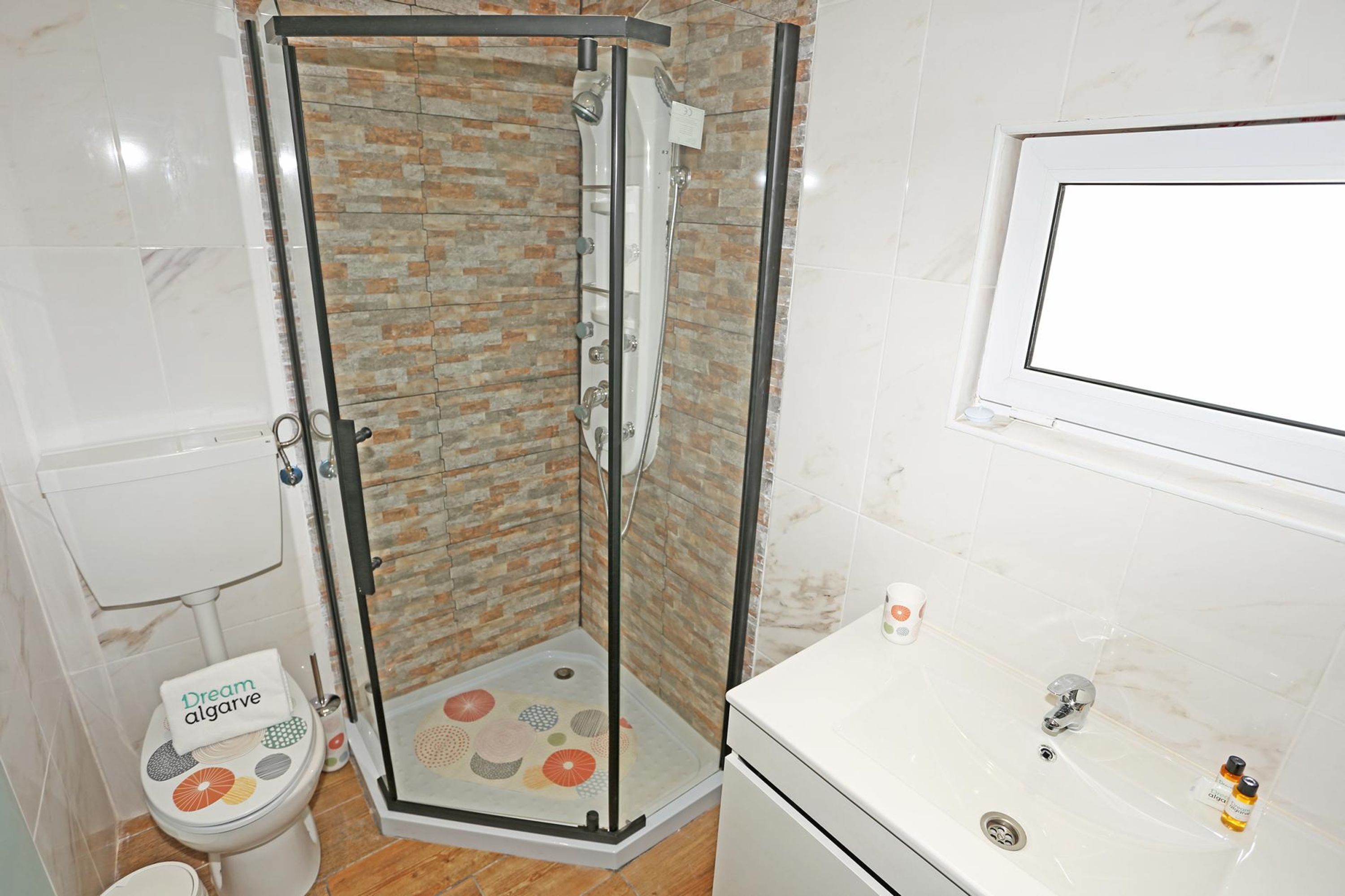 Un bagno con doccia, servizi igienici e lavabo.