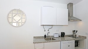 A compact kitchen with a built-in dishwasher, a stainless steel sink, and a white cabinet above the countertop. - X 05 - 1 Bed Apartment in Quinta da Ponte (Lagos)