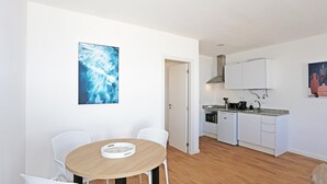 Una cocina moderna con armarios blancos, encimera de granito y horno empotrado.